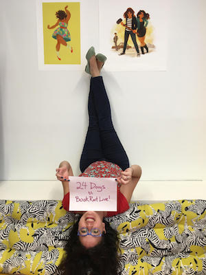 Rachel Fershleiser posing with a sign that says 24 Days Til Book Riot Live