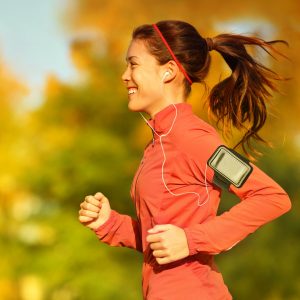 Woman runner running in fall autumn forest