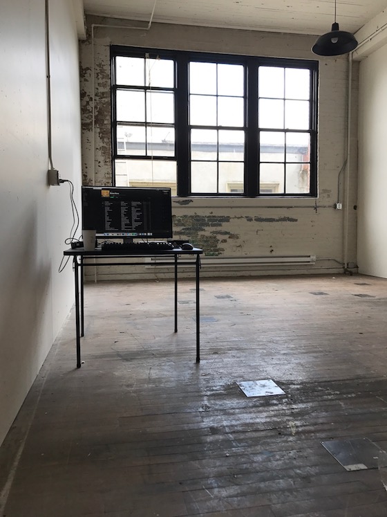 a very bare room with a large window, a desk, and a laptop -- no chair yet -- that will serve as the new Portland Book Riot office