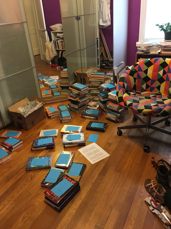 small stacks of books all over Rebecca's hardwood floor