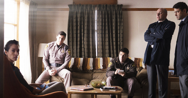 Shimmer Lake screenshot: 2 cops sittings, 2 FBI agents standing looking at a young woman sitting who is looking back at camera