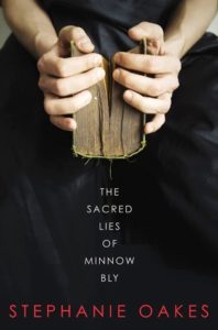 The Sacred Lies of Minnow Bly cover design: girl in all black zoomed in holding a book