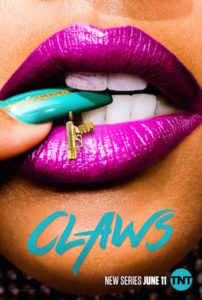 zoom in on a black woman's mouth with purple lipstick biting her teal fingernail with a gold gun charm hanging on it