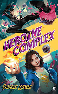 the cover of Heroine Complex, featuring two young asian women. One is wearing a black catsuit, kicking a cupcake with teeth. The other is wearing a hoodie and a tshirt and holds a ball of fire in her right hand.