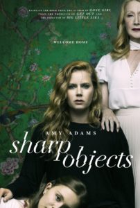 sharp objects show poster: a white woman sitting on a chair with an older white woman standing behinder her, hand on her shoulder, and a white teen with her head in the lap of the woman sitting down