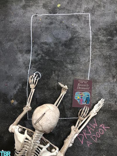 skeleton drawing a chalk door with Beetlejuice book