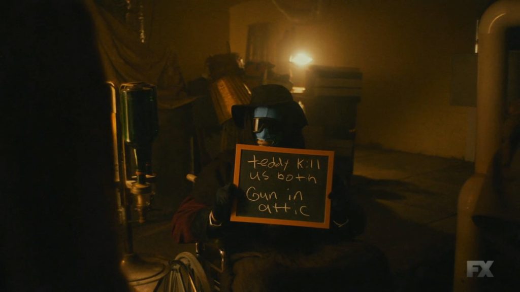 still of Teddy Perkins' brother holding sign that says "Teddy kill us both gun in attic," from the episode entitled "Teddy Perkins" from Atlanta's second season, ROBBIN' SEASON.