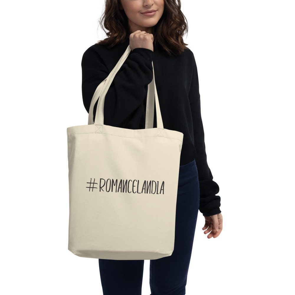 Photo of woman holding a tote bag that says "#Romancelandia"