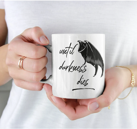 A coffee mug that says "until darkness dies"