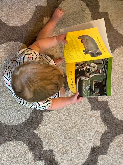 photo of a young child holding open a book