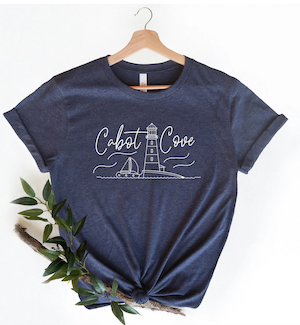 blue tshirt that says Cabot Cove with a line illustration of a lighthouse and sailboat