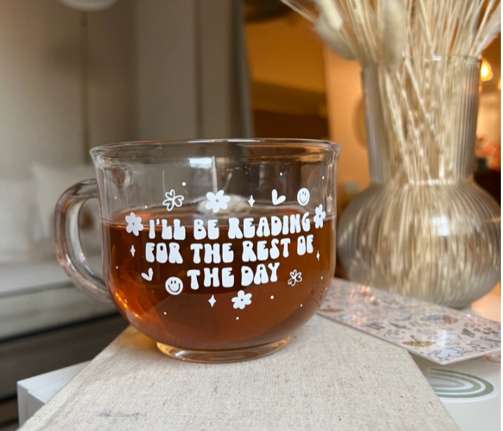 glass mug that says i'll be reading the rest of the day in white font