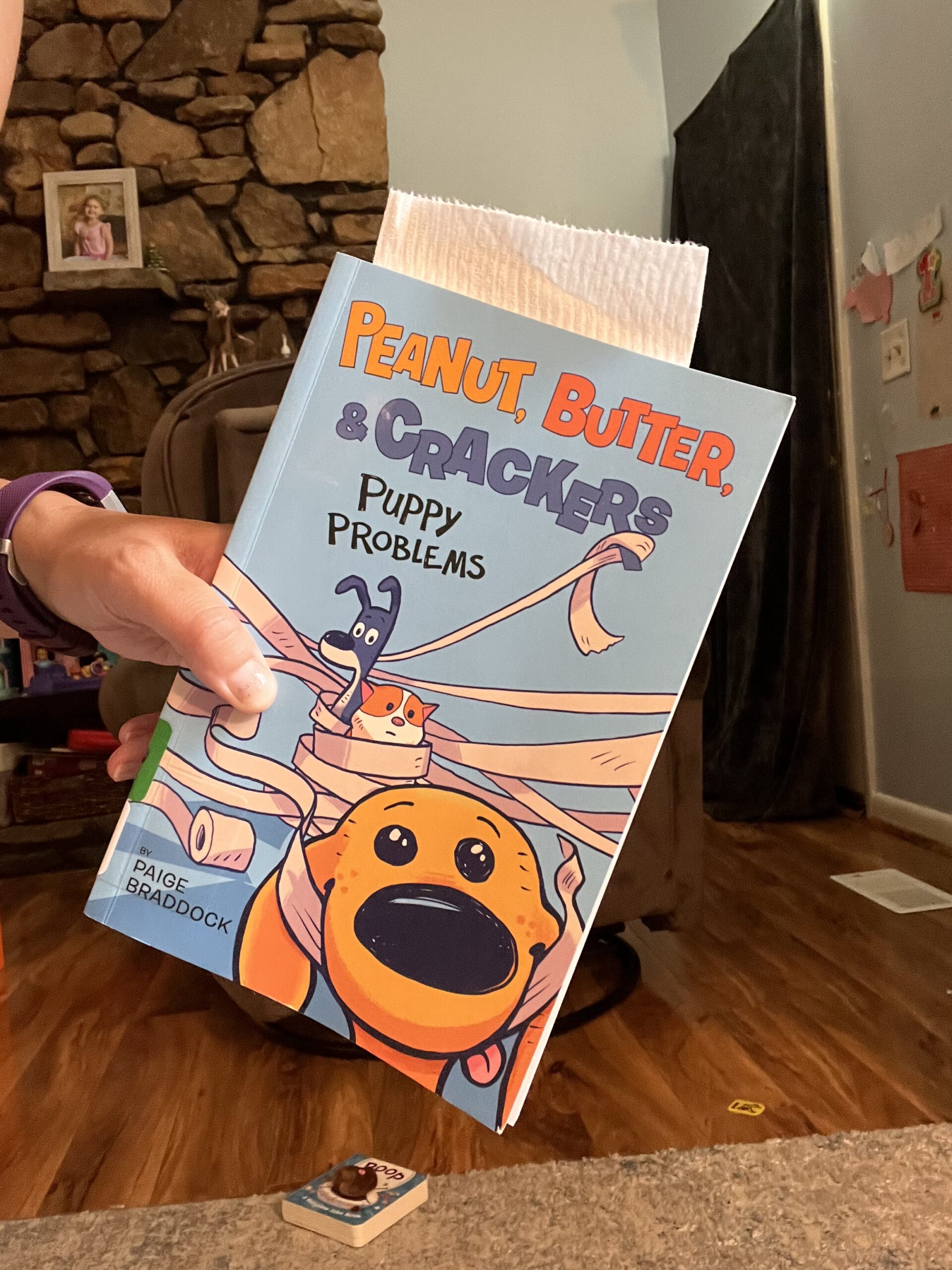The book Peanut, Butter, and Crackers: Puppy Problems with a toilet paper book mark