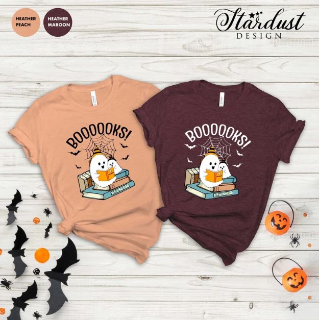 two t-shirts, one pale orange and one dark read, with illustrations of cartoon ghosts reading books 