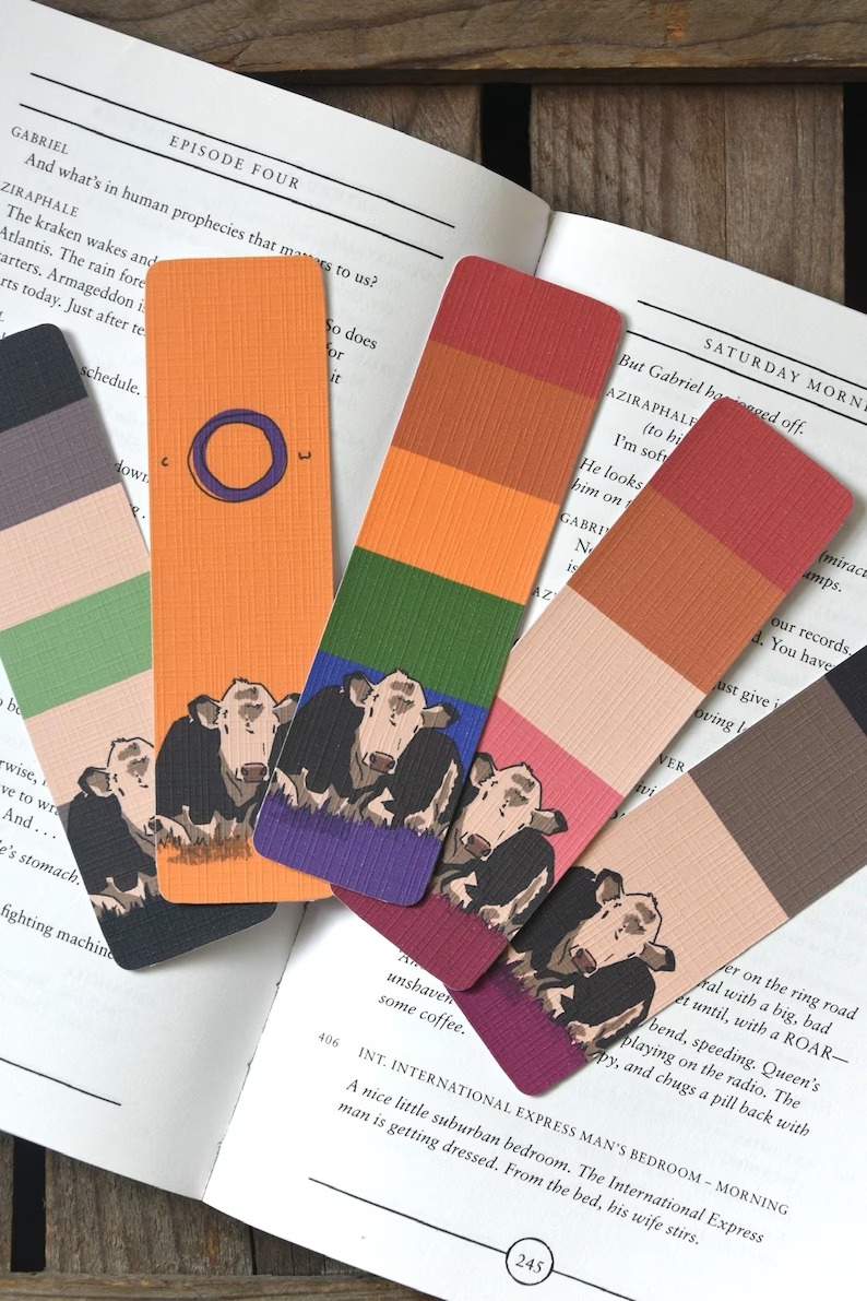 a photo of five bookmarks with cows and pride flag colors