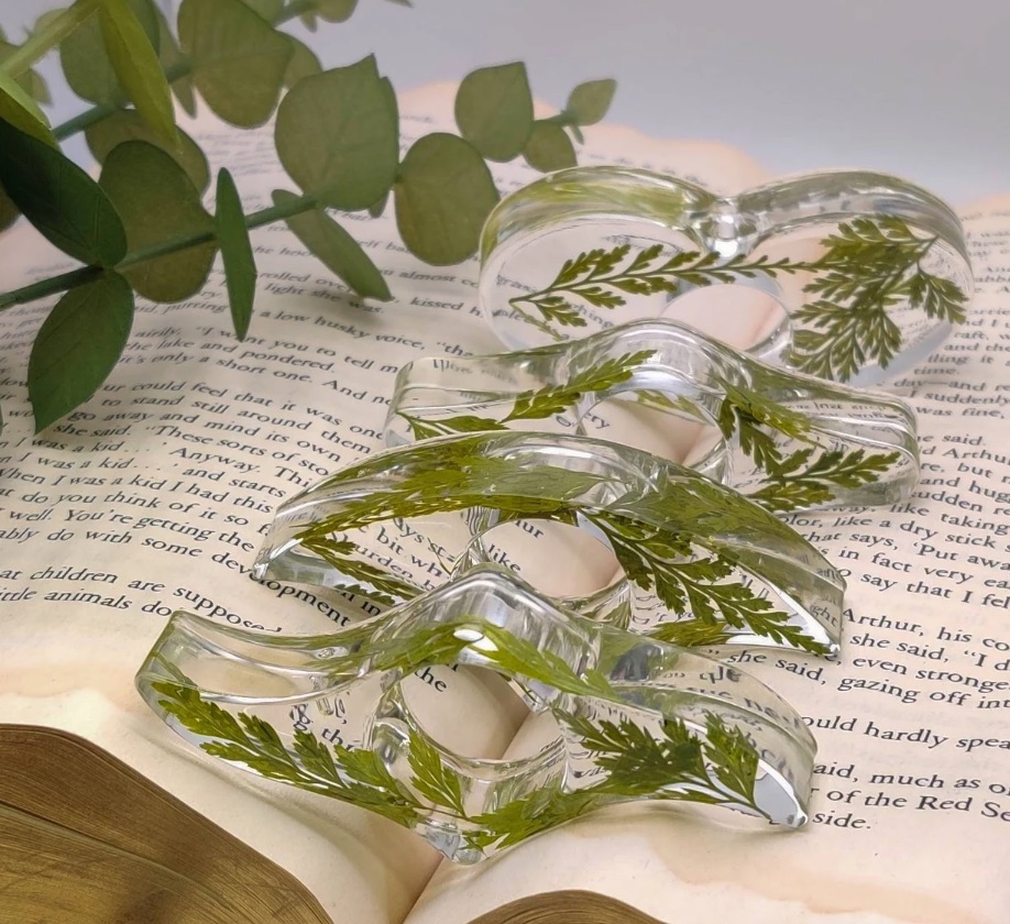 four page holders with plant leaves inside them