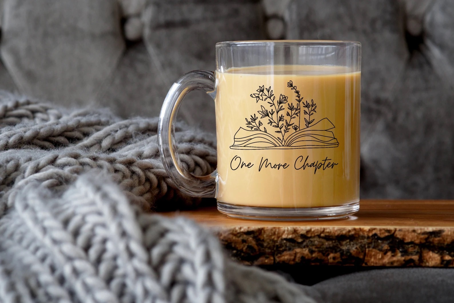 a photo of a clear glass mug that has an illustration of a book open with vines coming out of the book. It's giving big reading rainbow vibes but with plants