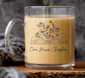 glass coffee mug that says "one more chapter" with an illustration of a book and flowers