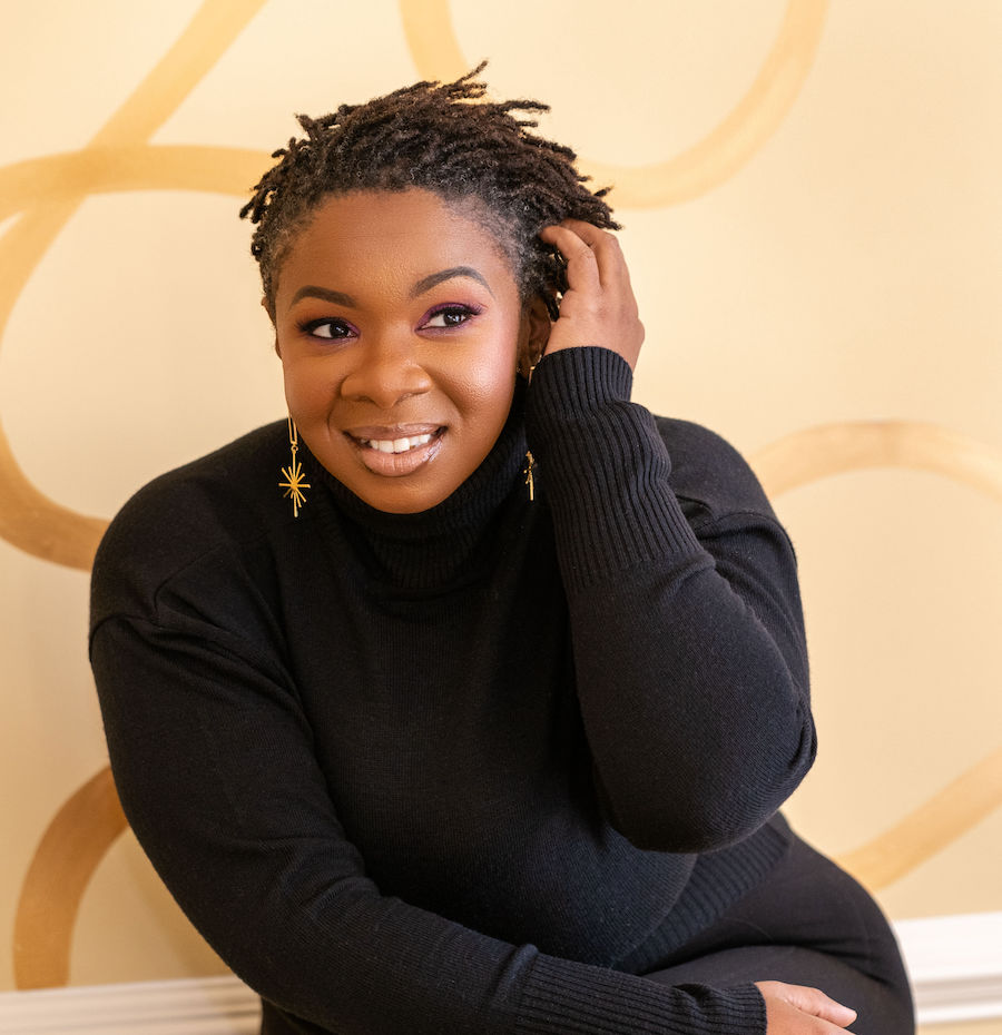 author photo of Nikki Payne, a Black woman wearing long gold earrings and a black high-neck sweater.