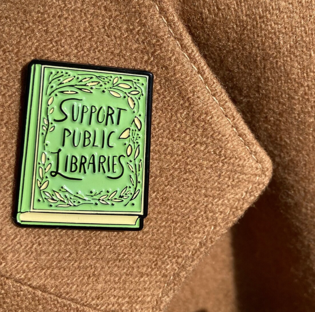 Green book pin that says Support Public Libraries