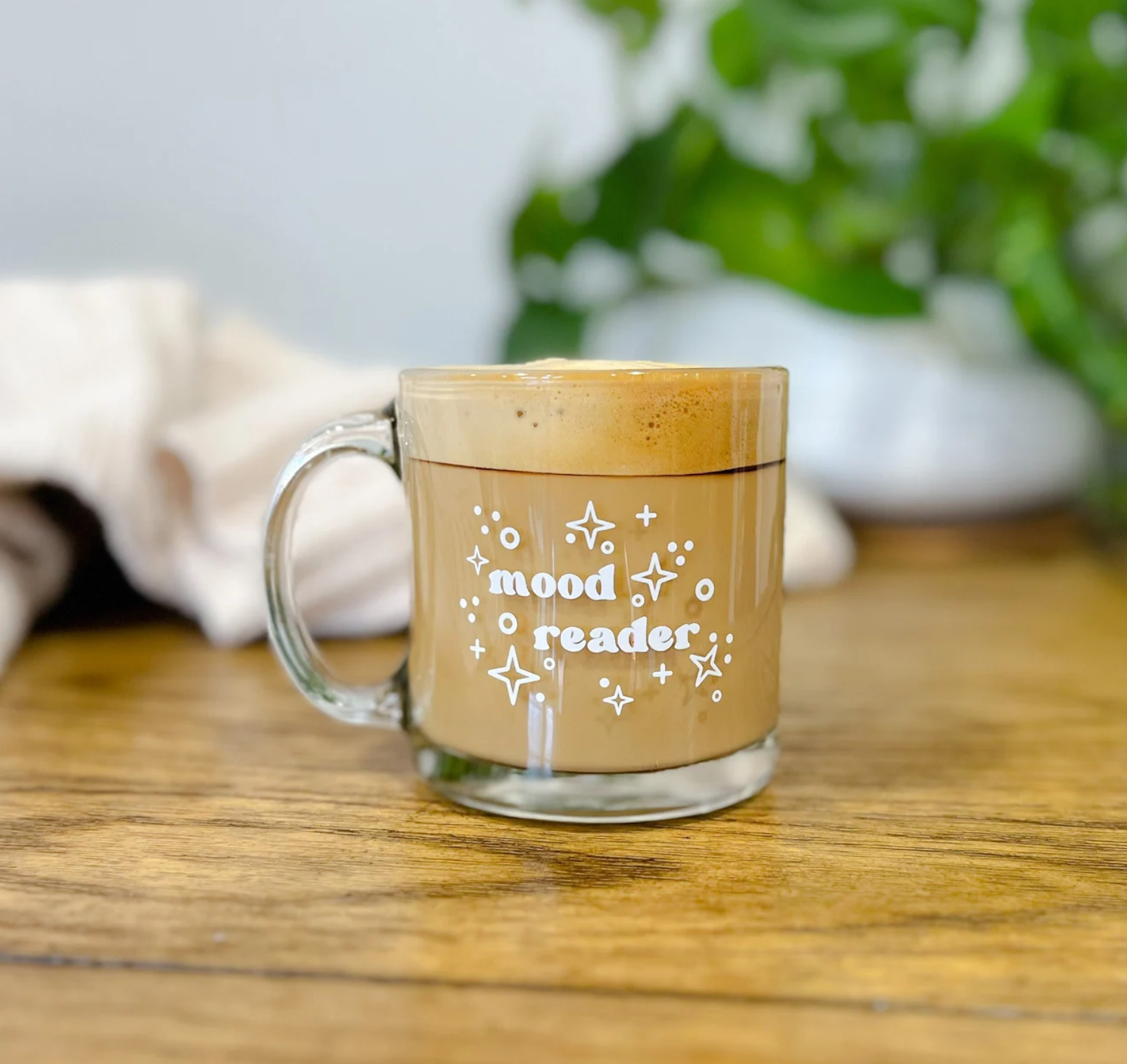 Glass mug with white text reading "mood reader" surrounded by stars