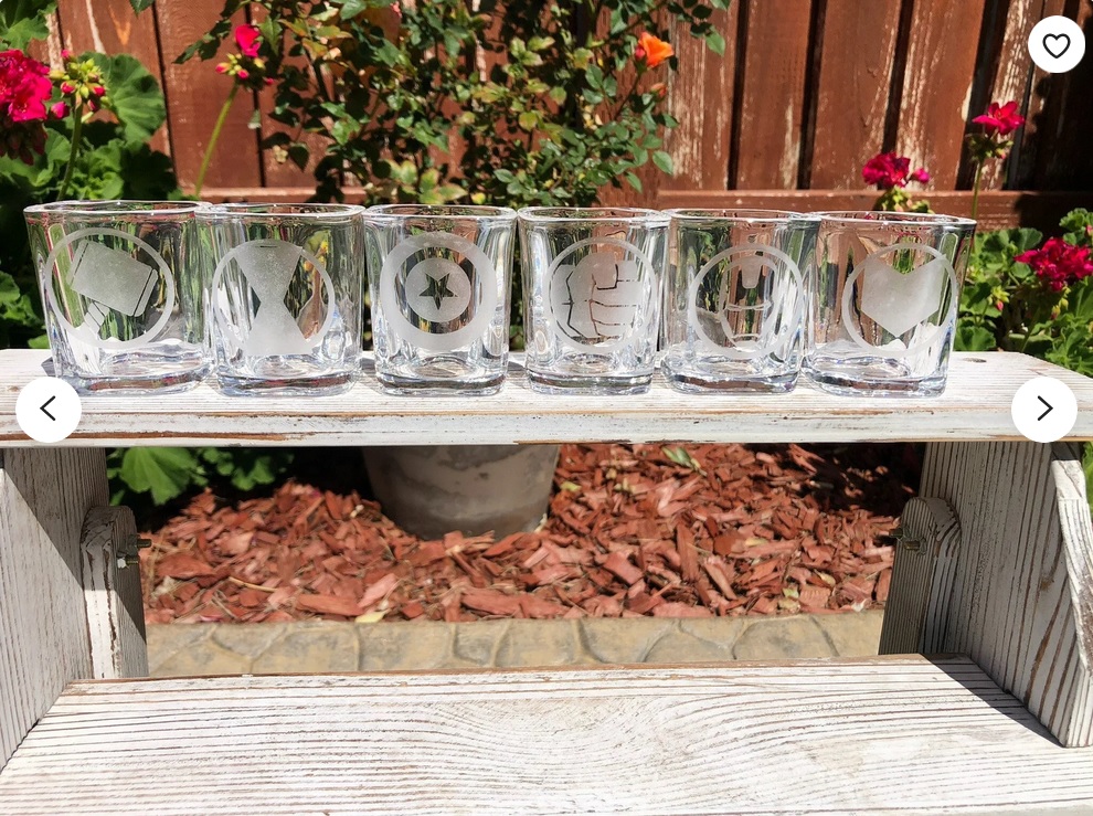 A line of shot glasses etched with the Avengers' logos