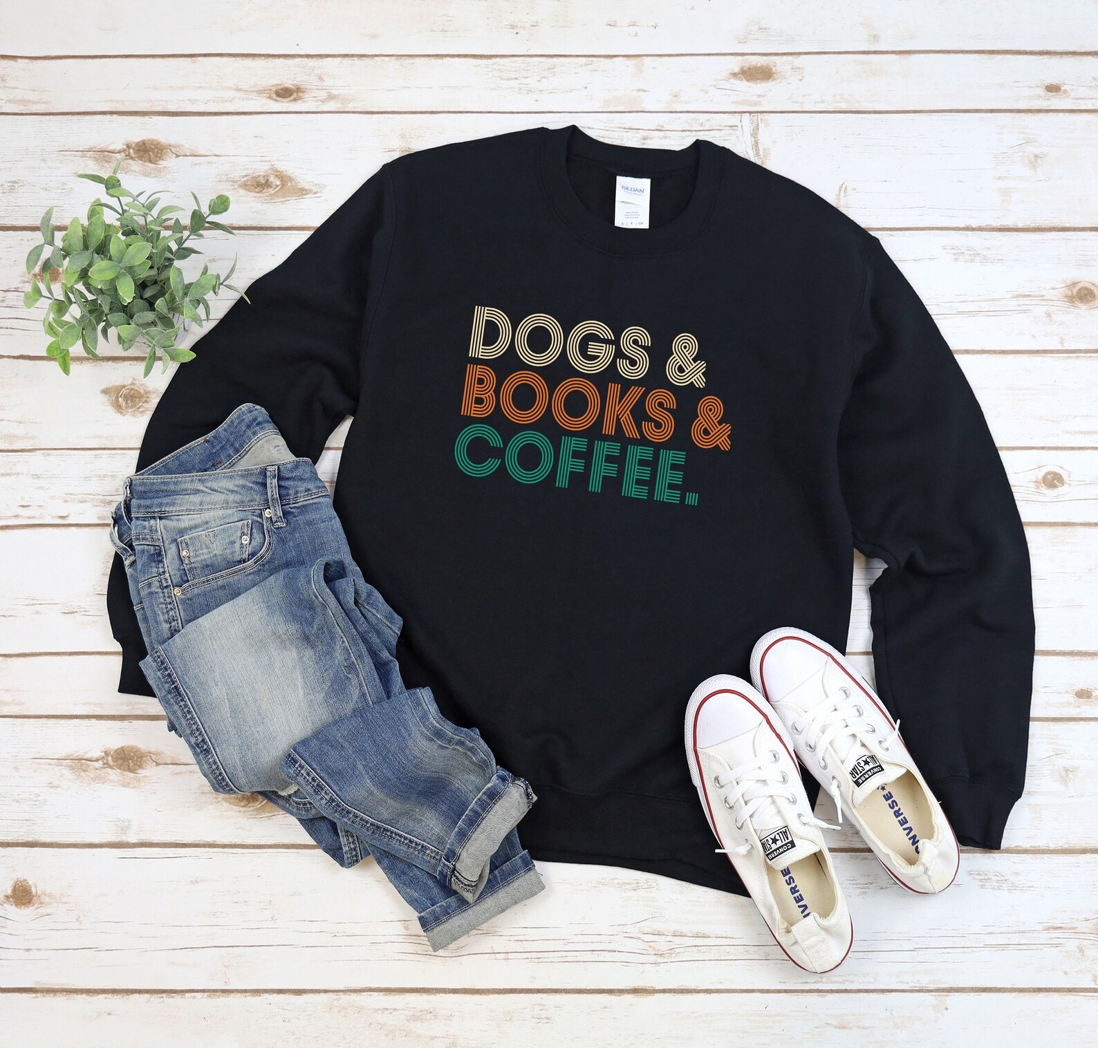 a photo of a sweatshirt that has the text "Dogs, Books, and Coffee."