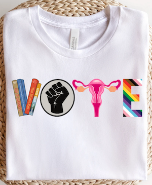 tshirt with the the letters spelling VOTE as designs of banned books, closed fist, uterus, LGBTQ+ rainbow