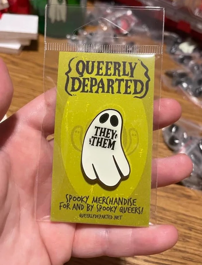 a photo of a ghost enamel pin with they/them on it