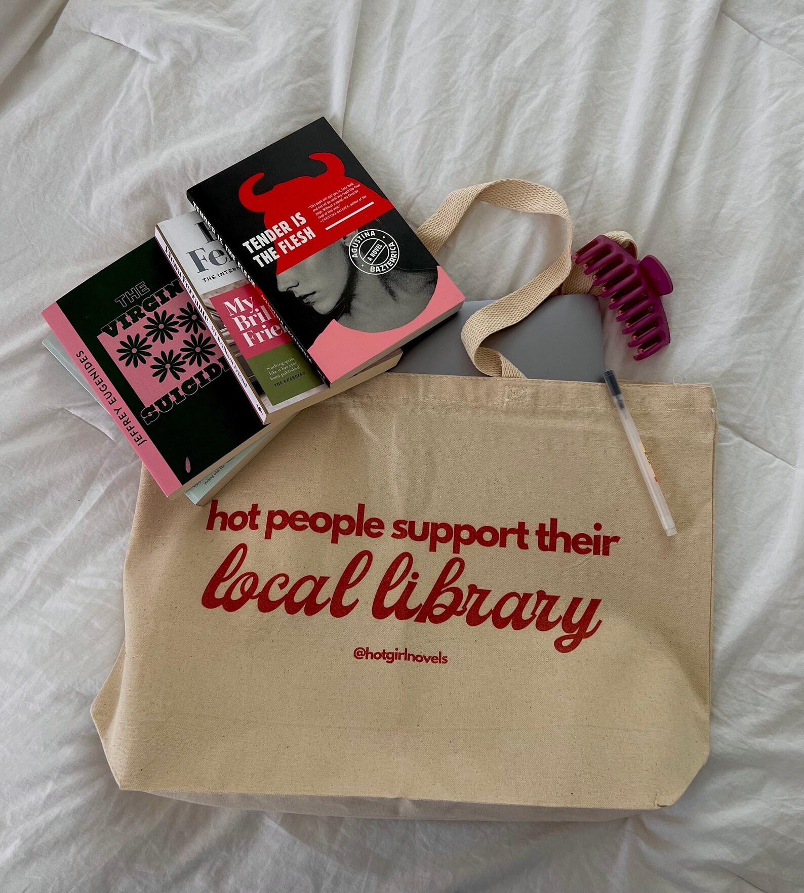 a photo of a tan tote bag that says, "hot girls support local libraries"