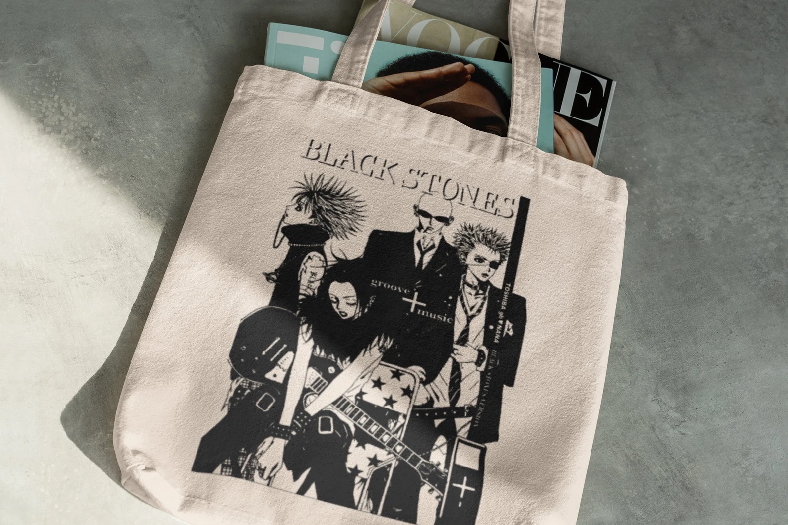 An off-white tote bag with a black-and-white image of the band Black Stones