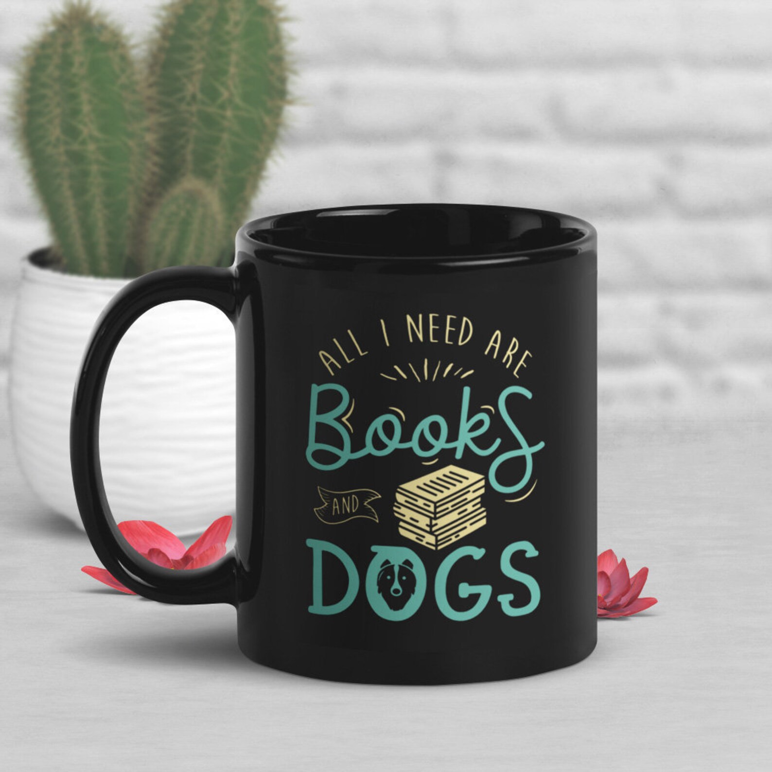a photo of a black mug that says, "All I need is books and dogs."