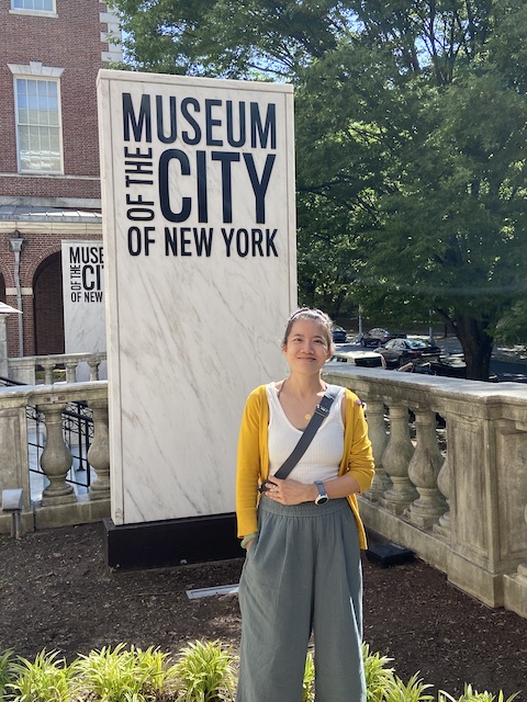 Karina Yan Glaser standing by the Museum of the City of New York sign
