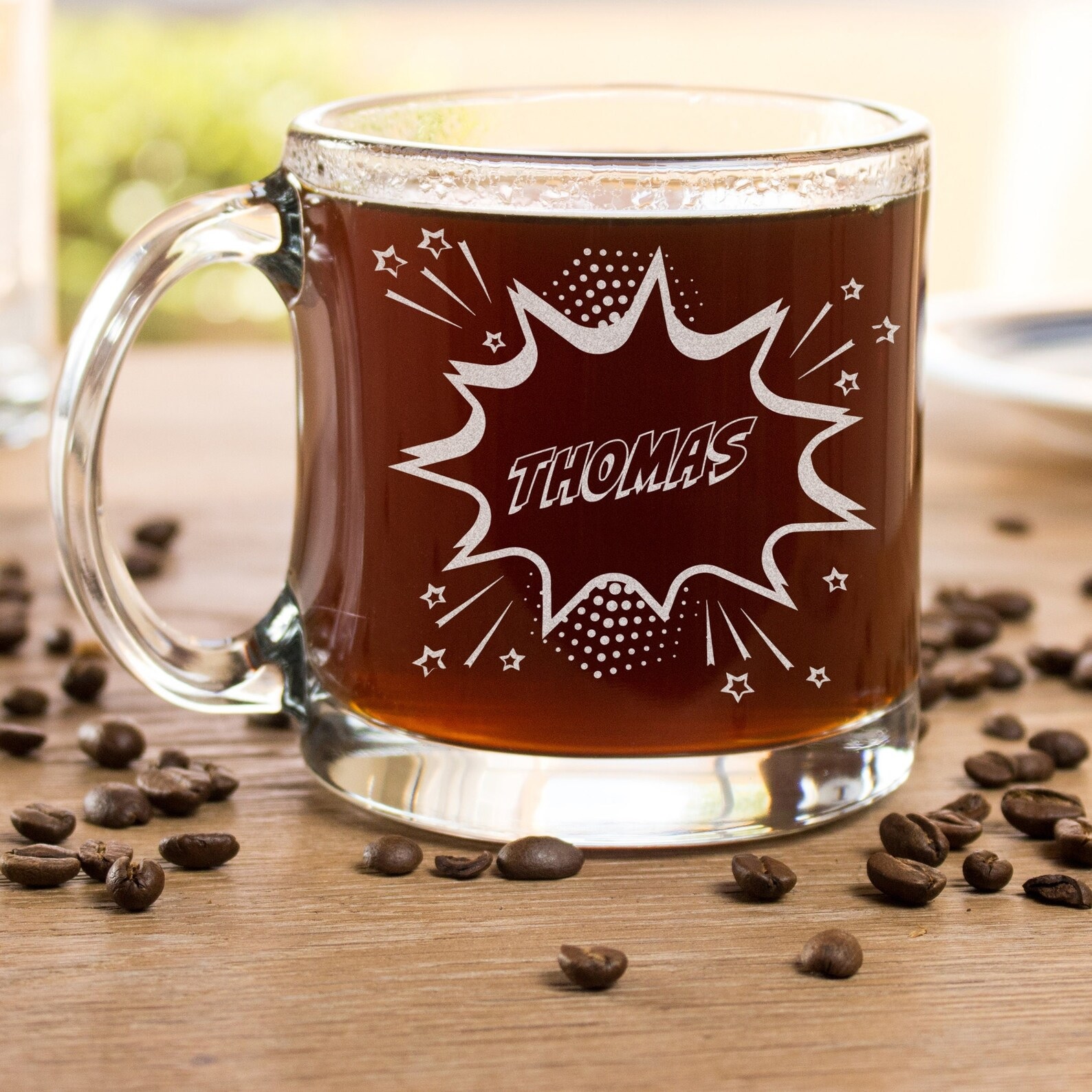 A glass coffee mug with a person's name inside a comics-style action bubble