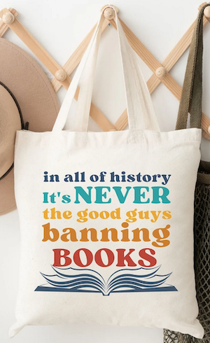 a tote bag with graphics that says "in all of history it's never the good guys banning books"