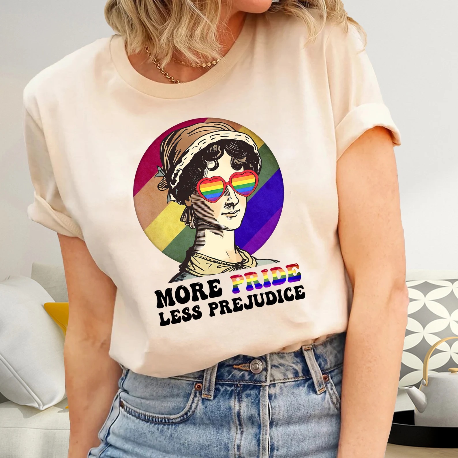 a t-shirt depicting Jane Austen on a rainbow background. She's also wearing rainbow glasses. The words "More Pride Less Prejudice" are below her