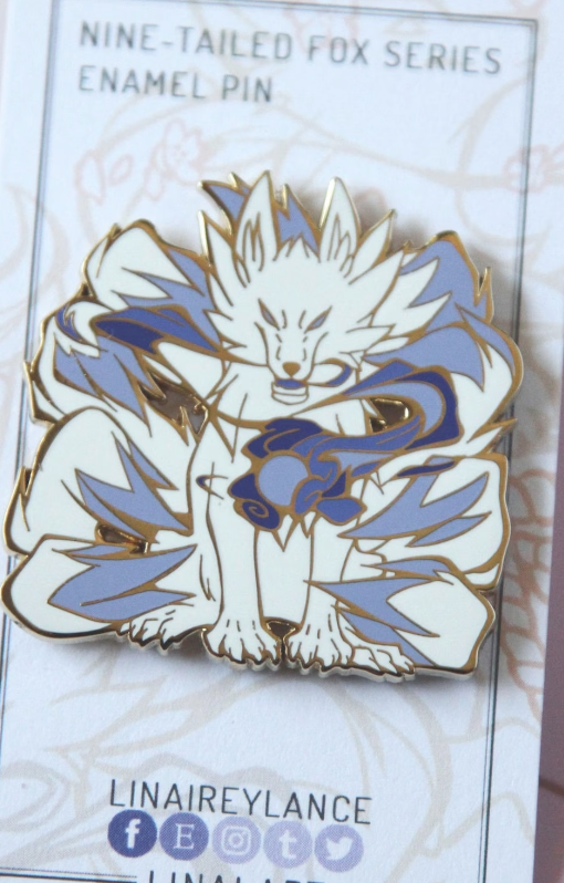 an enamel pin of a snarling nine-tailed fox
