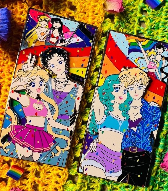 a photo of two large enamel pins showing Sailor Moon characters at a pride parade