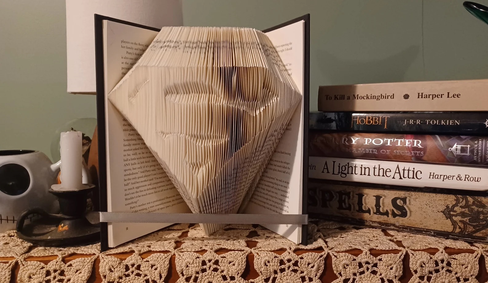 An open book where the pages have been cut into a 3D image of Superman's insignia