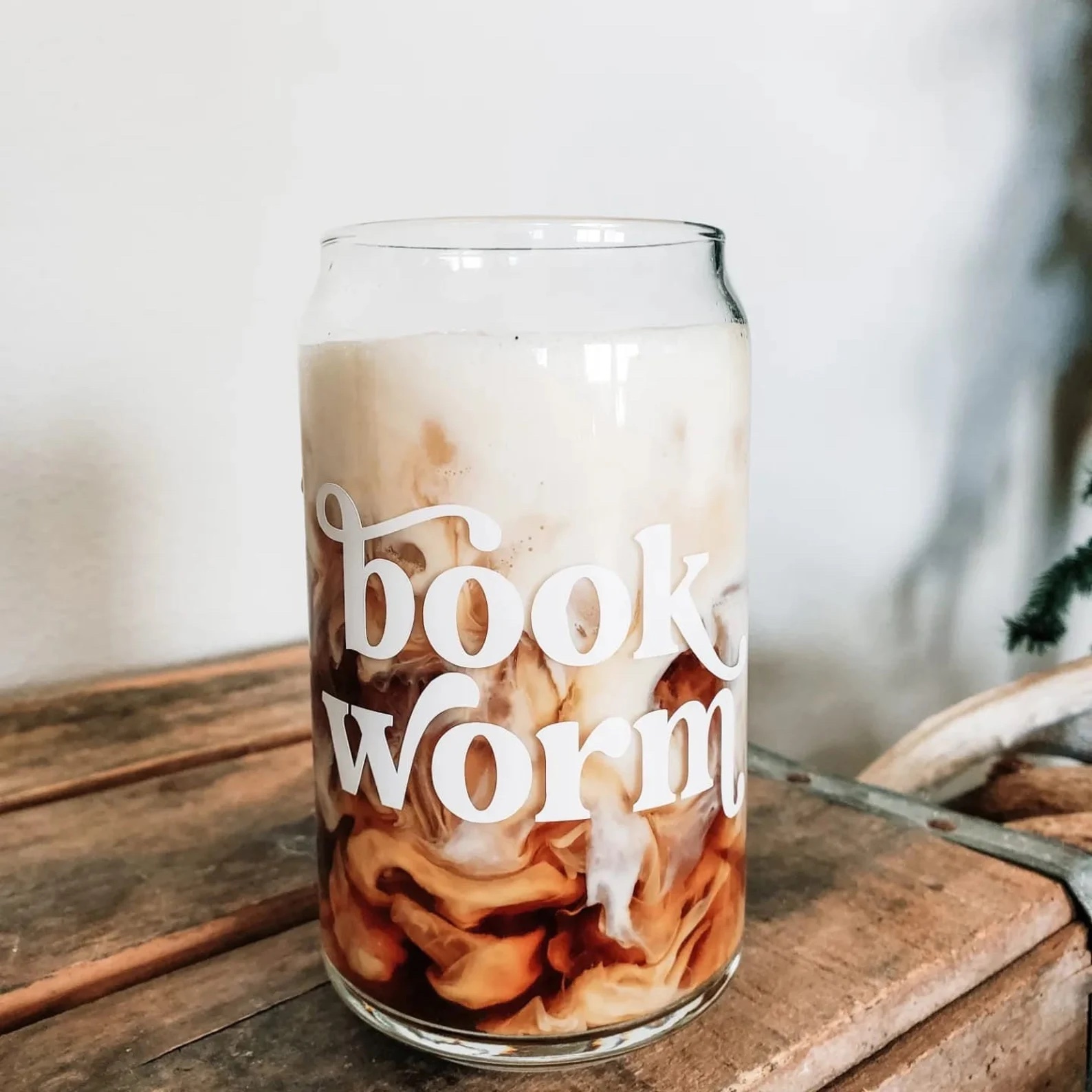 a photo of a tall clear glass with the text "bookworm" in white on the side