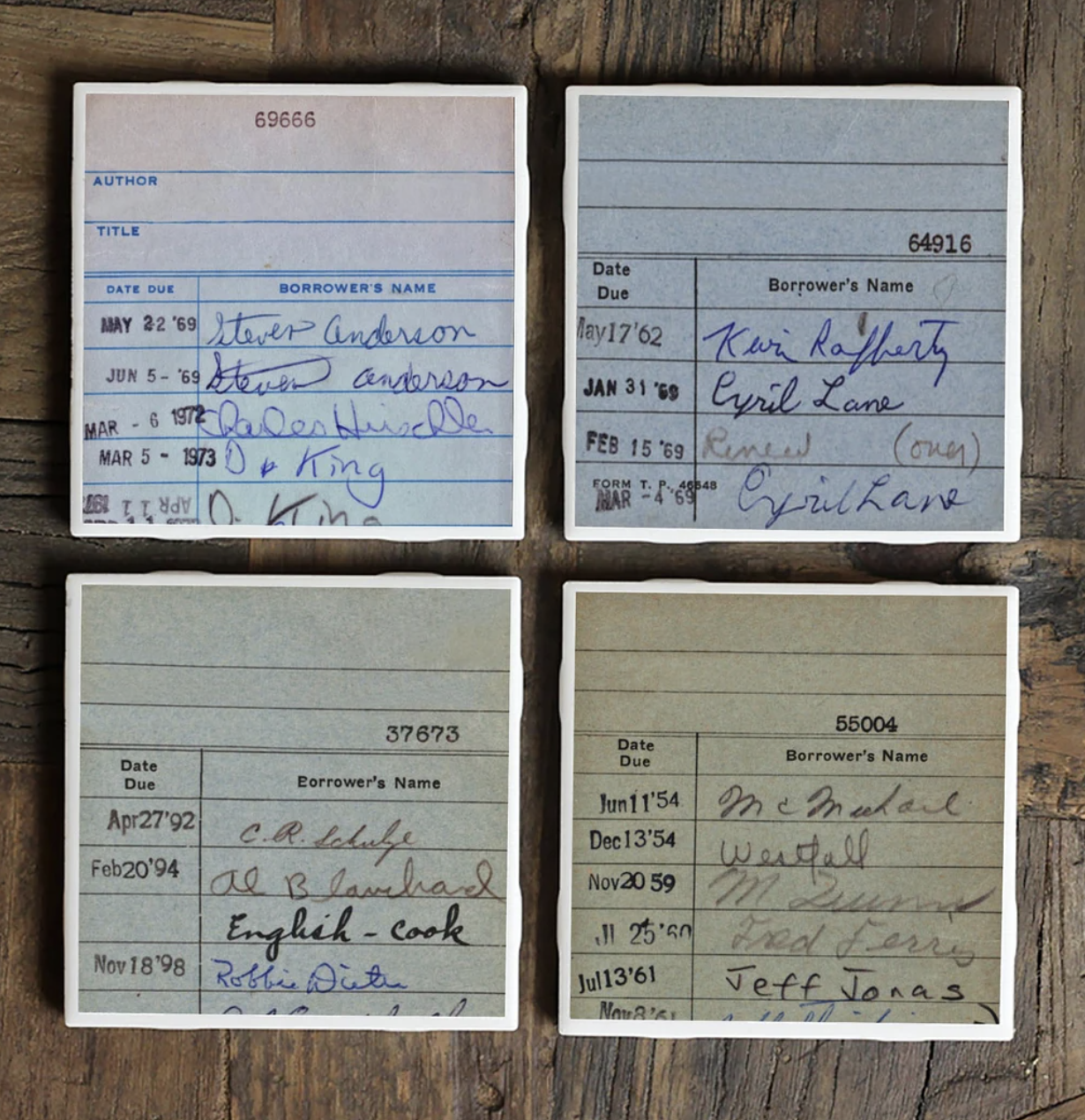 Square coasters printed to look like library cards in shades from white to tan with dates and signatures. 