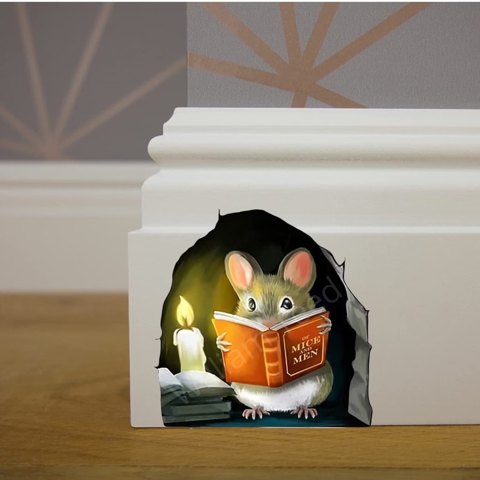 a photo of a wall decal of a mouse in his hole reading by candle light.