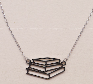 silver charm of a stack of books on a necklace