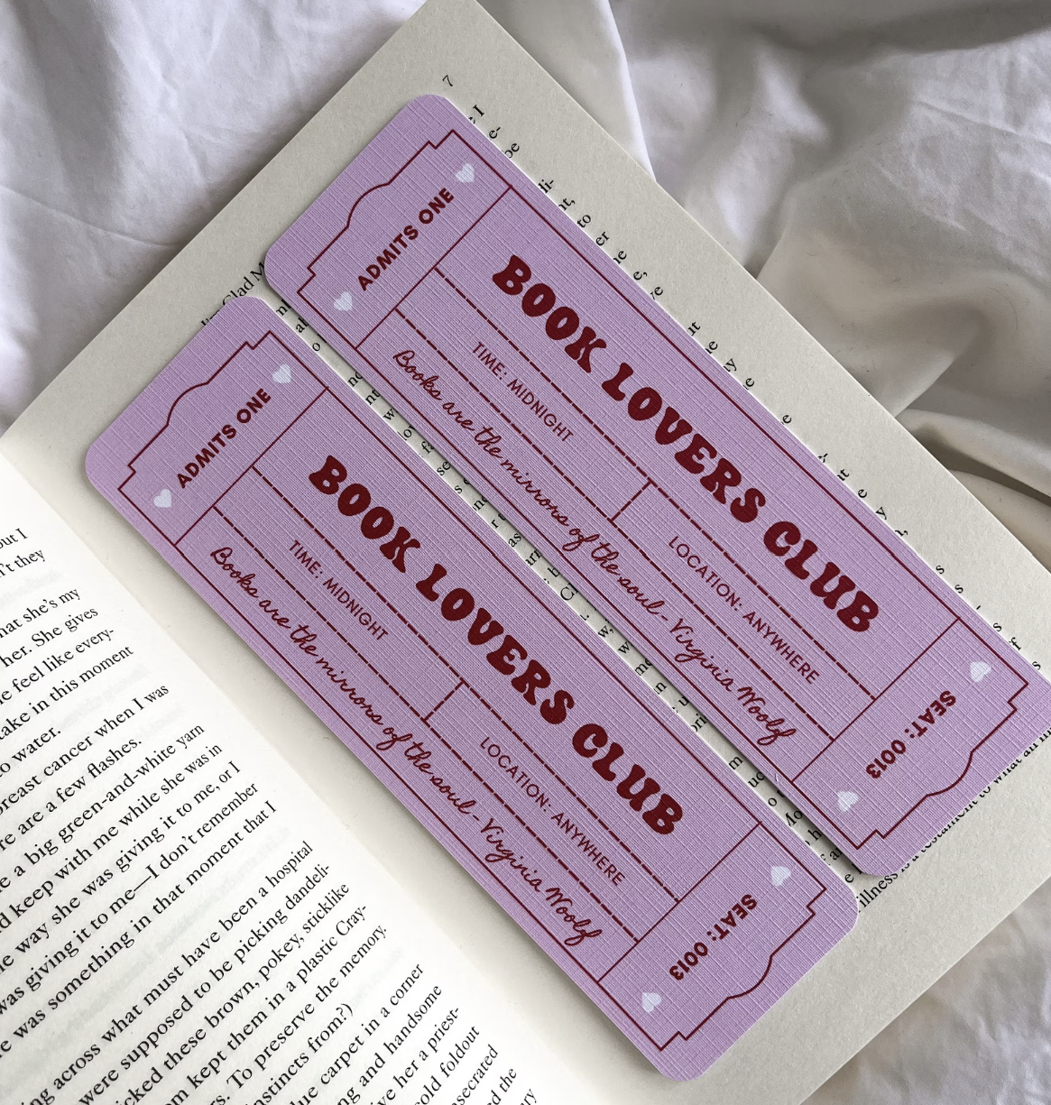 Pastel pink bookmarks designed to look like a carnival ticket with "admit one" on the sides that reads "Book Lovers Club" in red bubble font and features a quote from Virginia Woolf.