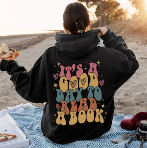 the back of a black hoodie with colorful bubble letters saying It's a good day to read a book