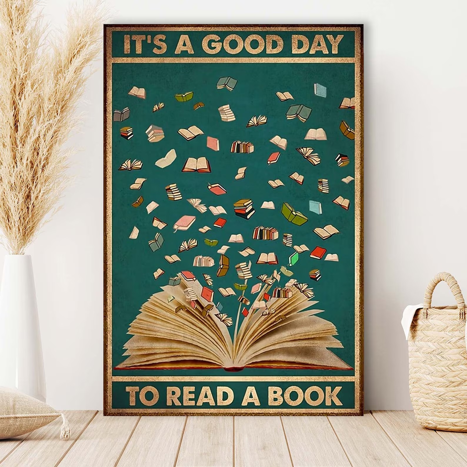 a photo of a print of visual art. The illustration features a large open book with a lot of tiny books flying out of it. The text reads, "It's a good day to read a book." 