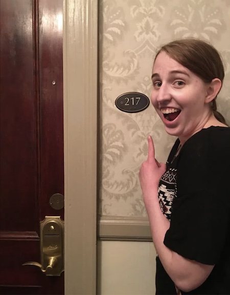 Katie points excitedly at the sign outside Room 217 at the Stanley Hotel