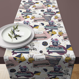a table runner with colorful illustrations of stacks of books and typewriters