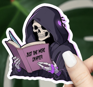 illustrated sticker of a skeleton reading a book that says "just one more chapter"