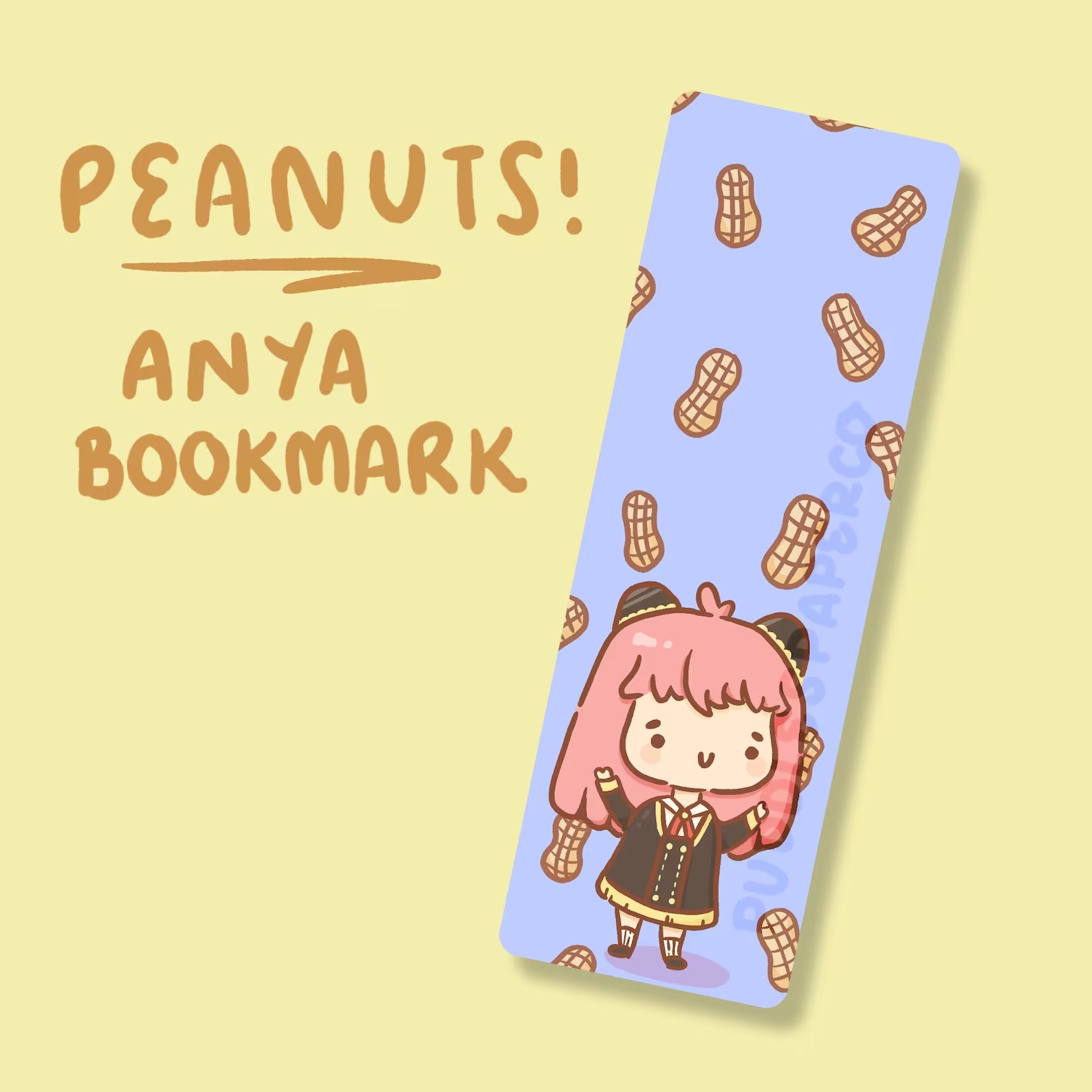 A blue bookmark featuring a chibi Anya from Spy x Family. She is smiling with her hands up in the air as peanuts ran down in the background.